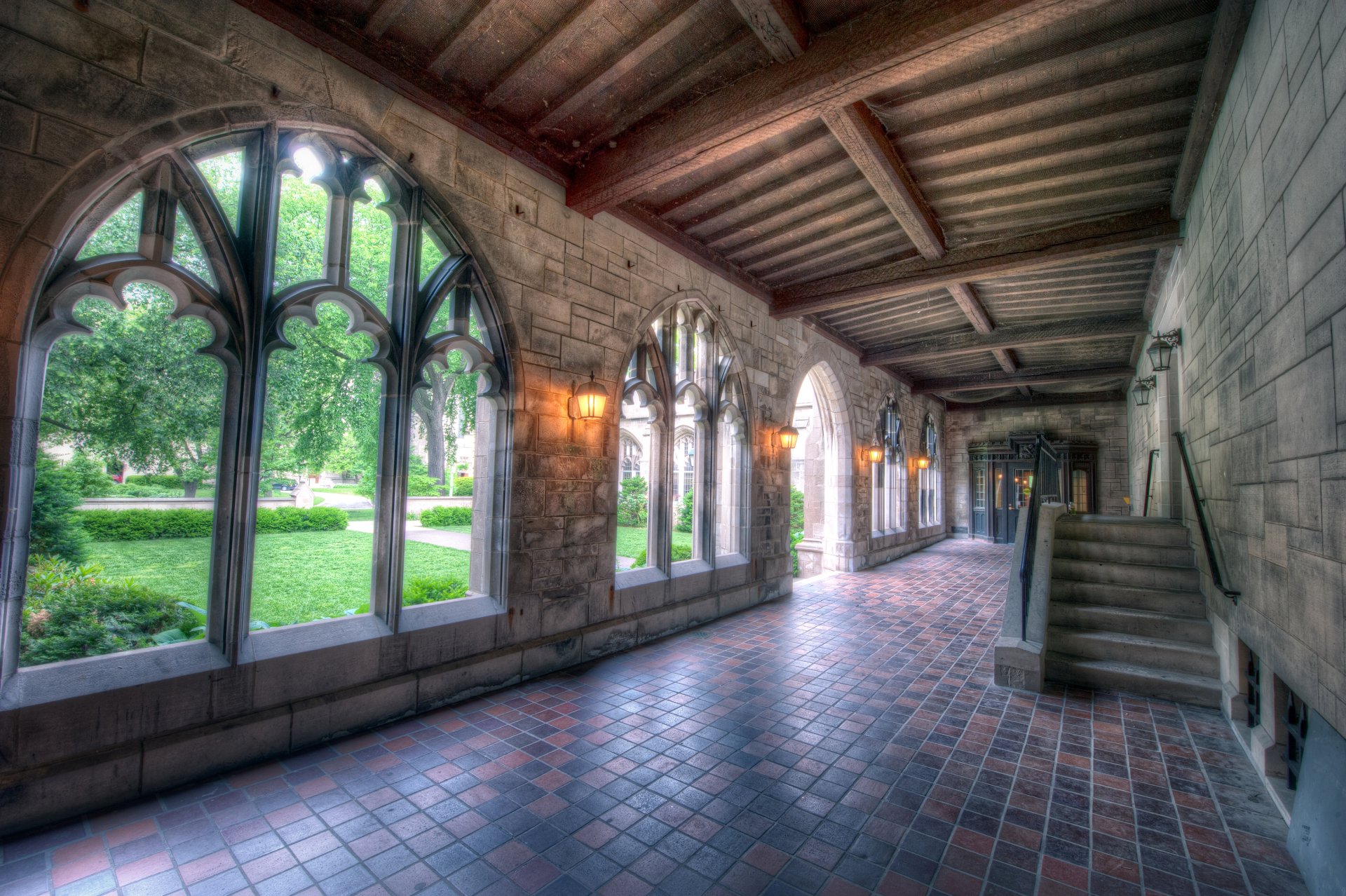 4K Ultra HD wallpaper featuring a man-made mansion corridor with Gothic arches, stone walls, and a view of lush greenery outside.