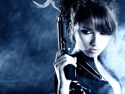 A bold woman with dark hair, dressed in a sleek outfit, confidently holds a gun against a backdrop of swirling smoke, creating a striking HD wallpaper for desktop backgrounds.
