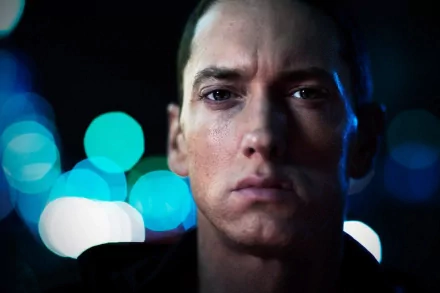 HD desktop wallpaper featuring Eminem with a serious expression against a backdrop of blurred, colorful lights.