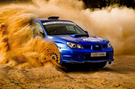 A dynamic Subaru rally car kicks up dust while navigating a rugged terrain, capturing the thrilling essence of rallying in this stunning 4K Ultra HD desktop wallpaper.