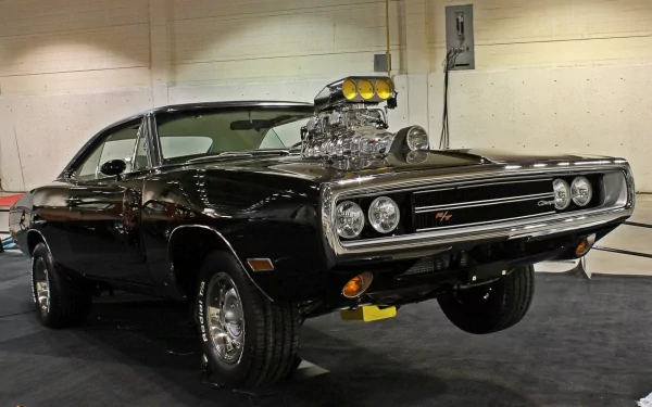 A striking Dodge Charger R/T with a prominent blower, showcased in a sleek black finish, featured as a high-definition PC desktop wallpaper and background.