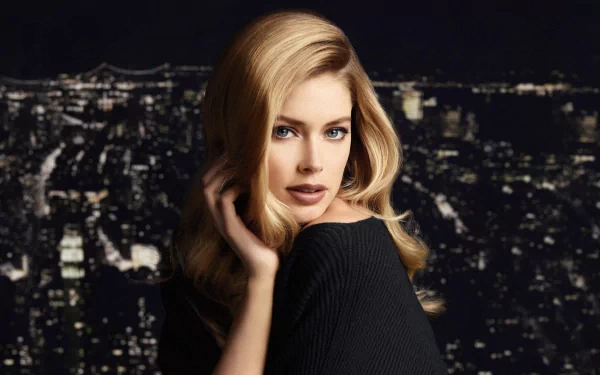 A striking HD desktop wallpaper featuring celebrity Doutzen Kroes against a night city skyline, showcasing her elegance and beauty in a captivating, modern setting.