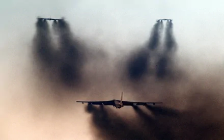 HD desktop wallpaper featuring a Boeing B-52 Stratofortress military aircraft flying through thick black smoke.