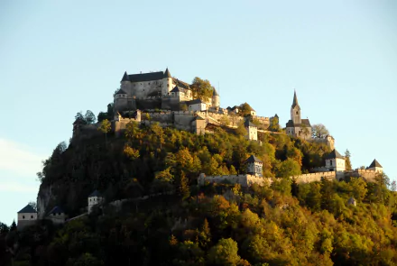 A stunning 4K Ultra HD wallpaper showcasing Hochosterwitz Castle perched atop a lush, forested hill under a clear sky.