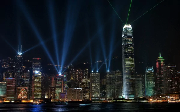 HD desktop wallpaper showcasing Hong Kong's man-made skyline illuminated with vibrant lights and laser beams over the harbor at night.