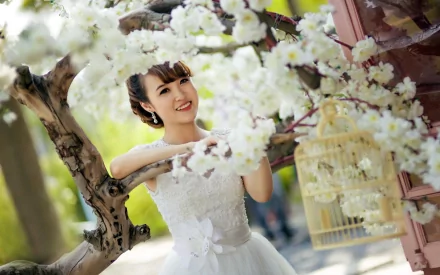 A smiling bride in a beautiful white dress stands among delicate white flowers, exuding joy and elegance in this HD desktop wallpaper.