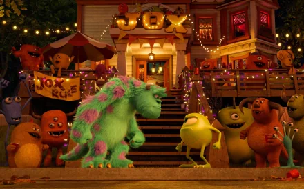 James P. Sullivan and Mike Wazowski from Monsters University stand surrounded by colorful monsters at a lively outdoor scene, complete with festive decorations and smiles.