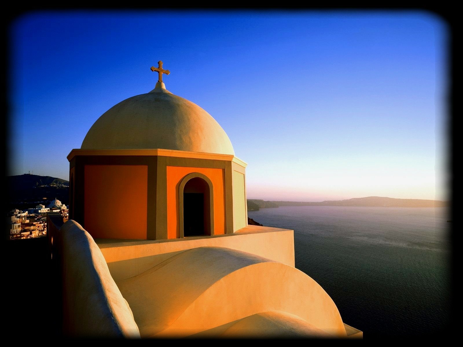 HD PC desktop wallpaper: man-made whitewashed Santorini church dome with cross overlooking the Aegean at sunset.