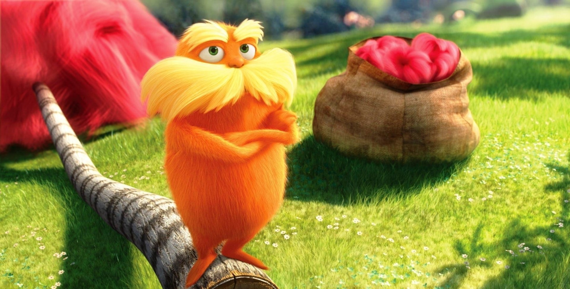 HD PC desktop wallpaper from the movie The Lorax featuring the orange, mustached Lorax character standing on a branch with a sack of red fruit in the background.