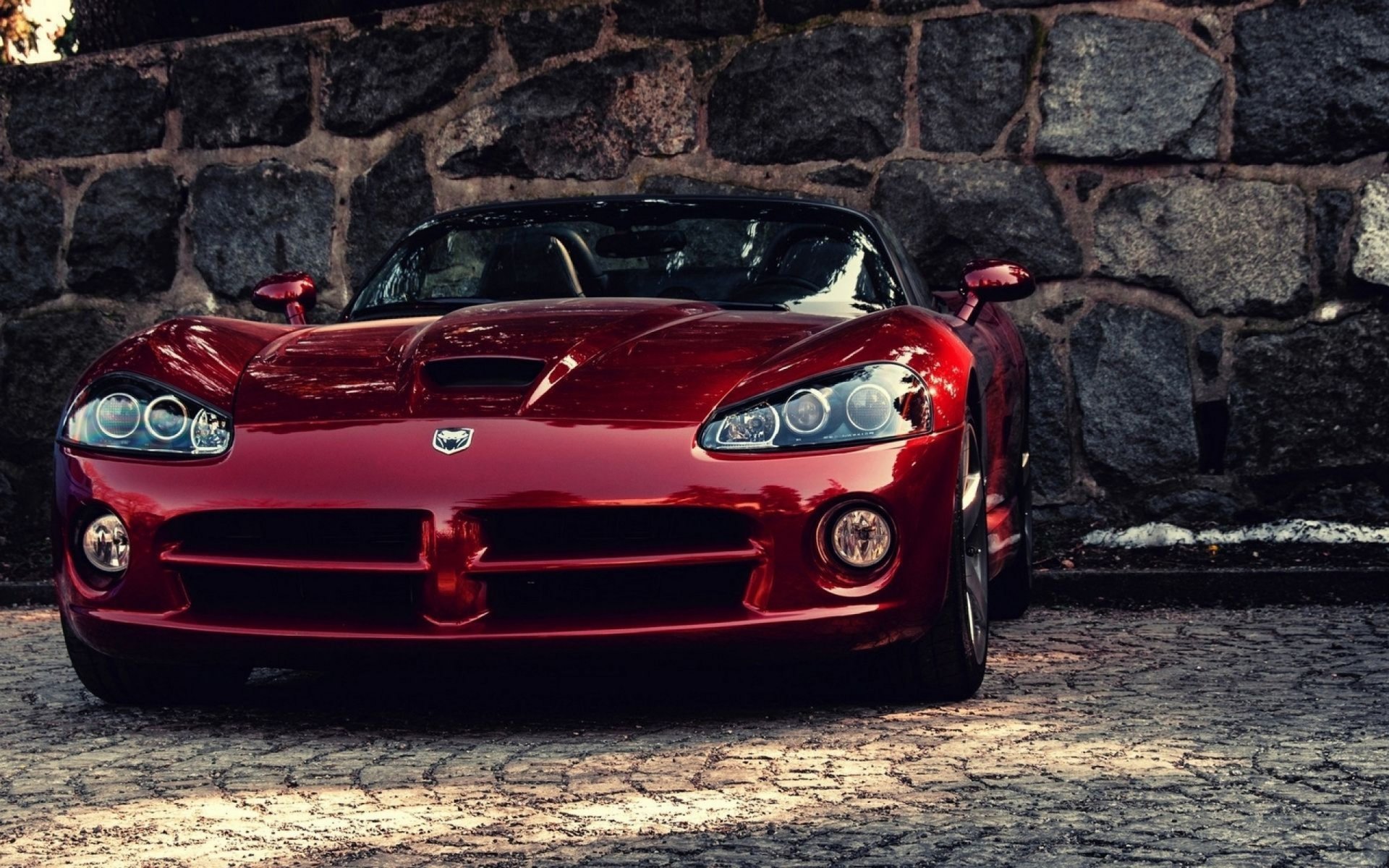 Red Dodge Viper SRT front view parked on cobblestone beside a stone wall — 2K Quad HD PC desktop wallpaper/background.