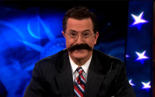 HD desktop wallpaper featuring Stephen Colbert from The Colbert Report, with a patriotic-themed background.