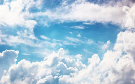 HD PC desktop wallpaper featuring a vibrant blue sky filled with soft, billowing white clouds, highlighting the beauty of nature and open skies.