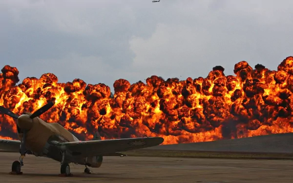 A military aircraft is stationed in front of a dramatic explosion, creating a striking HD wallpaper that captures the intensity of conflict.
