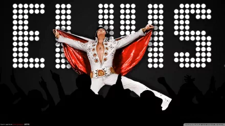 A vibrant HD desktop wallpaper featuring Elvis Presley performing energetically, adorned in a flashy white outfit with a red cape, against a backdrop of bright lights showcasing his name.
