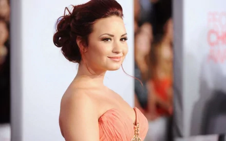 Demi Lovato smiles in elegant attire, captured at a glamorous event. This HD wallpaper adds a vibrant touch to any PC desktop background for music fans.