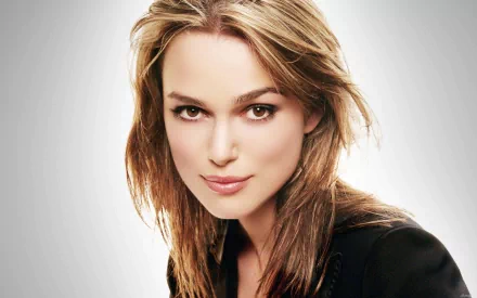 HD wallpaper featuring celebrity Keira Knightley, showcasing her confident expression and stylish look against a soft, gradient background.