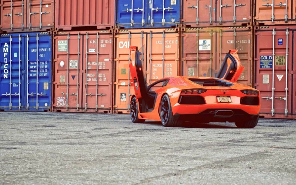 HD desktop wallpaper featuring an orange Lamborghini Aventador with its doors open, parked in front of colorful shipping containers.