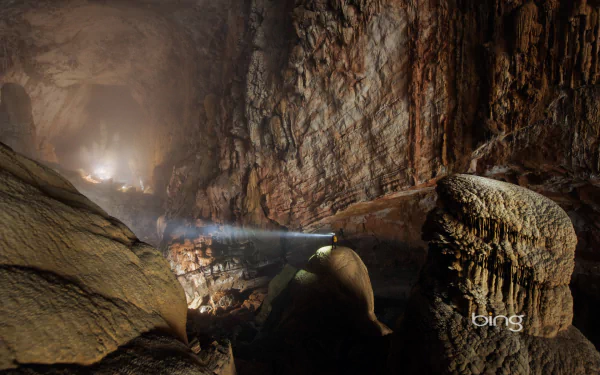 Inside Son Doong Cave, Vietnam’s largest underground cave, a beam of light illuminates the rugged rock formations in this HD nature wallpaper.