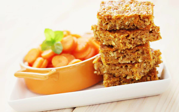 HD PC desktop wallpaper featuring a close-up of stacked oat bars and a bowl of sliced carrots on a white plate, highlighting wholesome food and pie elements.