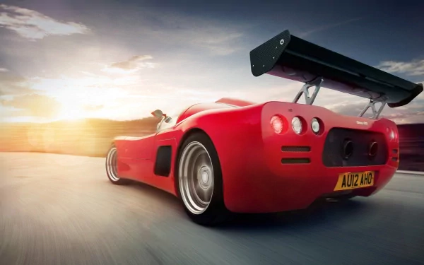 HD PC desktop wallpaper featuring a red Ultima GTR sports car speeding on a road at sunset, showcasing its sleek design and large rear spoiler.