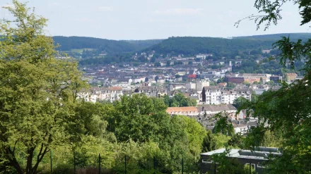 Wuppertal cityscape viewed from a green hillside, houses and man-made buildings framed by trees — 5K Ultra HD PC desktop wallpaper background.