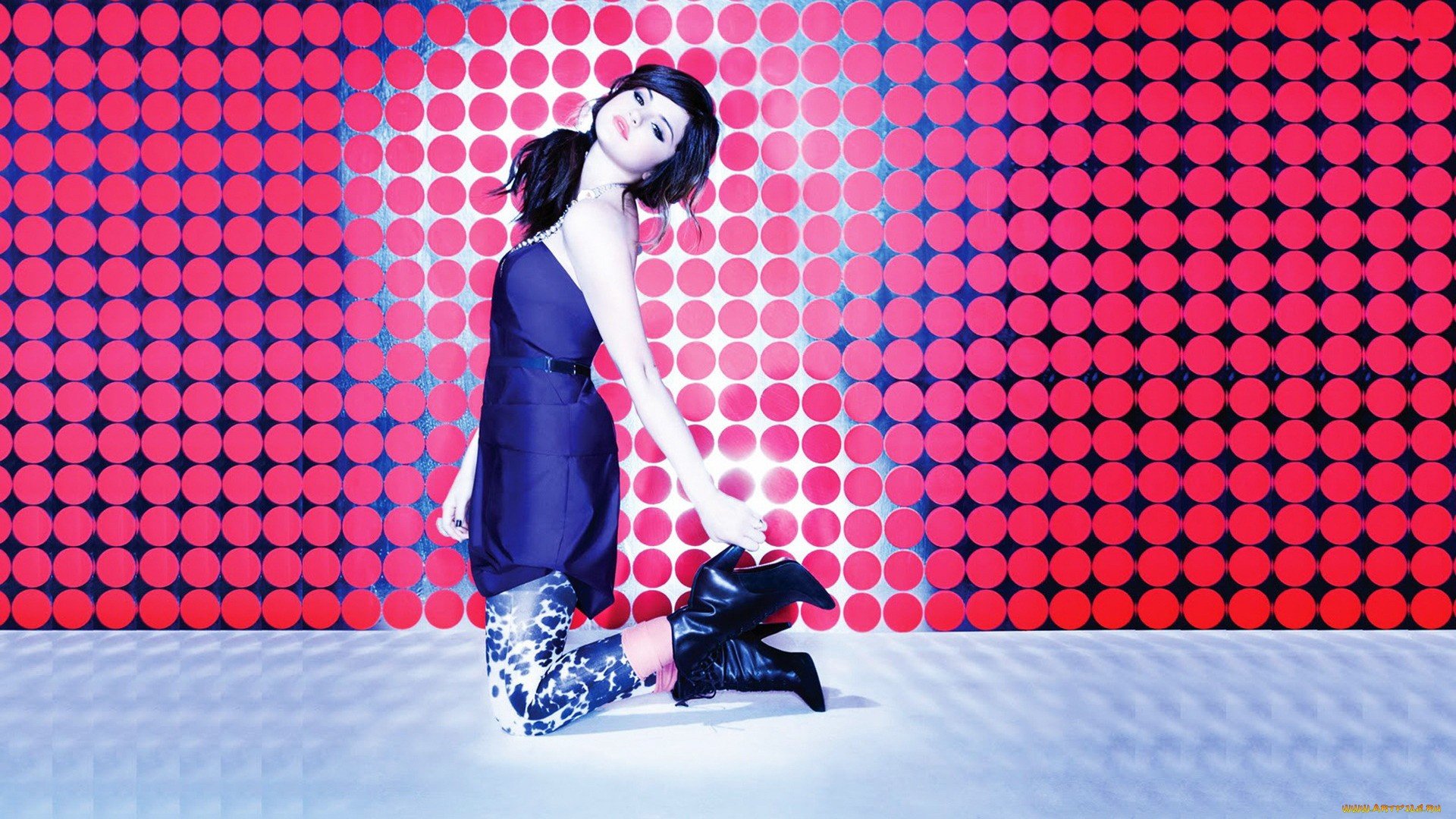 HD PC desktop wallpaper featuring Selena Gomez posing against a vibrant red and blue patterned backdrop, blending music and style elements in a modern design.