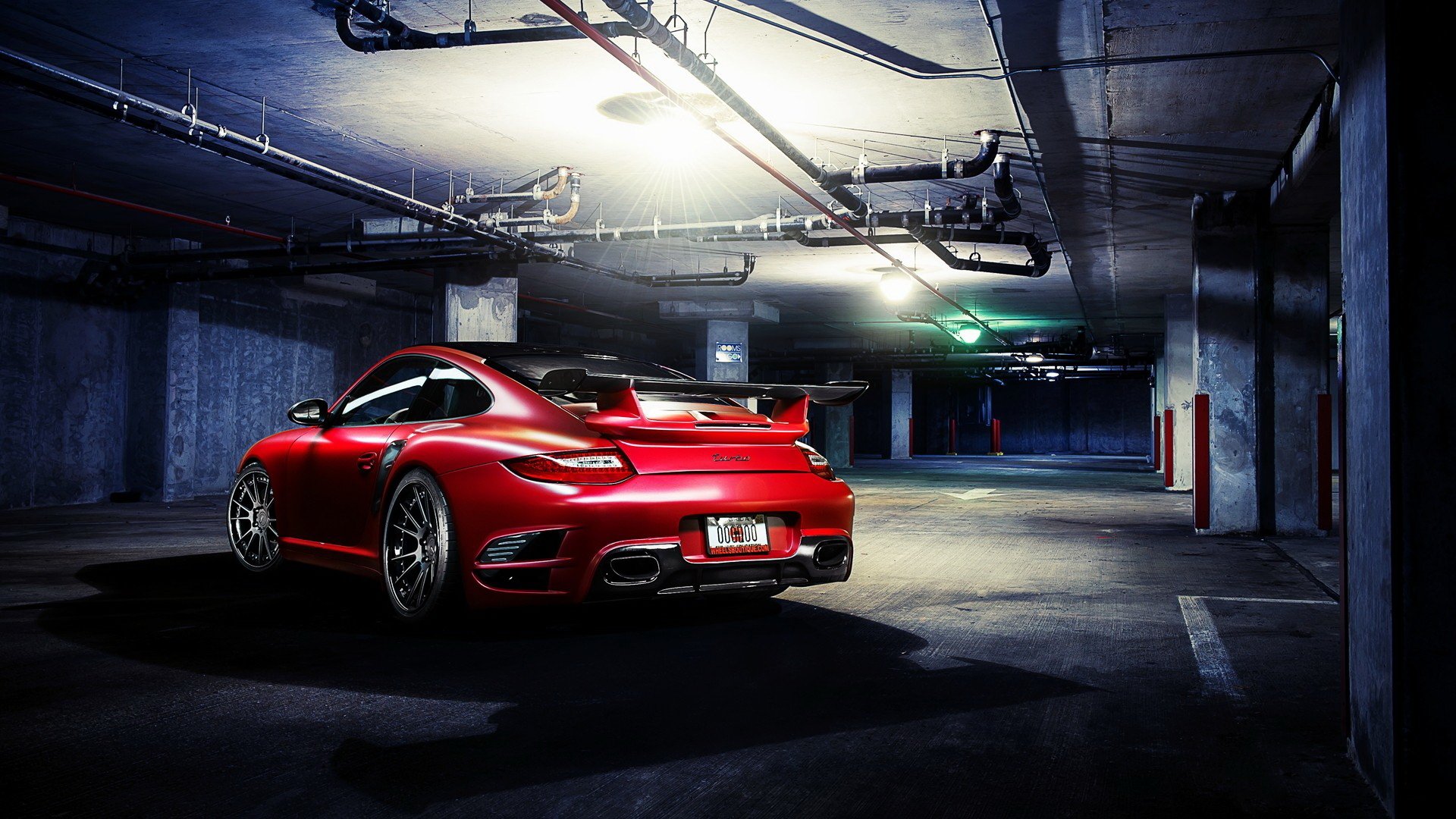 HD PC desktop wallpaper featuring a red Porsche 911 parked in a dimly lit underground garage.