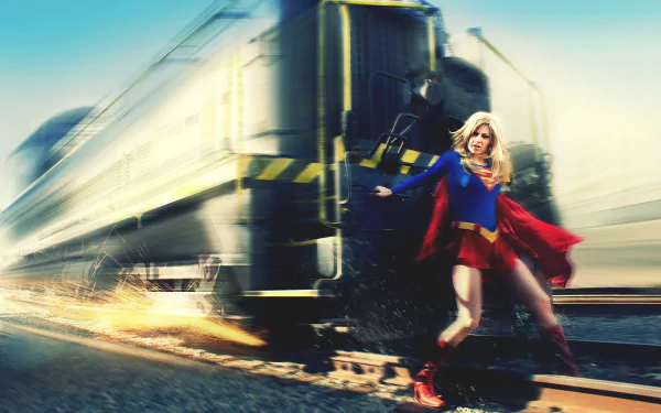 HD PC desktop wallpaper featuring a dynamic comic-style Supergirl standing confidently on train tracks with a speeding train in the background.