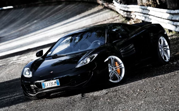 Black McLaren MP4-12C supercar parked on a winding road, showcased as a high-definition PC desktop wallpaper and background.