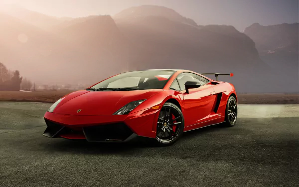 HD PC desktop wallpaper featuring a red Lamborghini Gallardo parked on a textured surface with misty mountains and soft sunlight in the background.