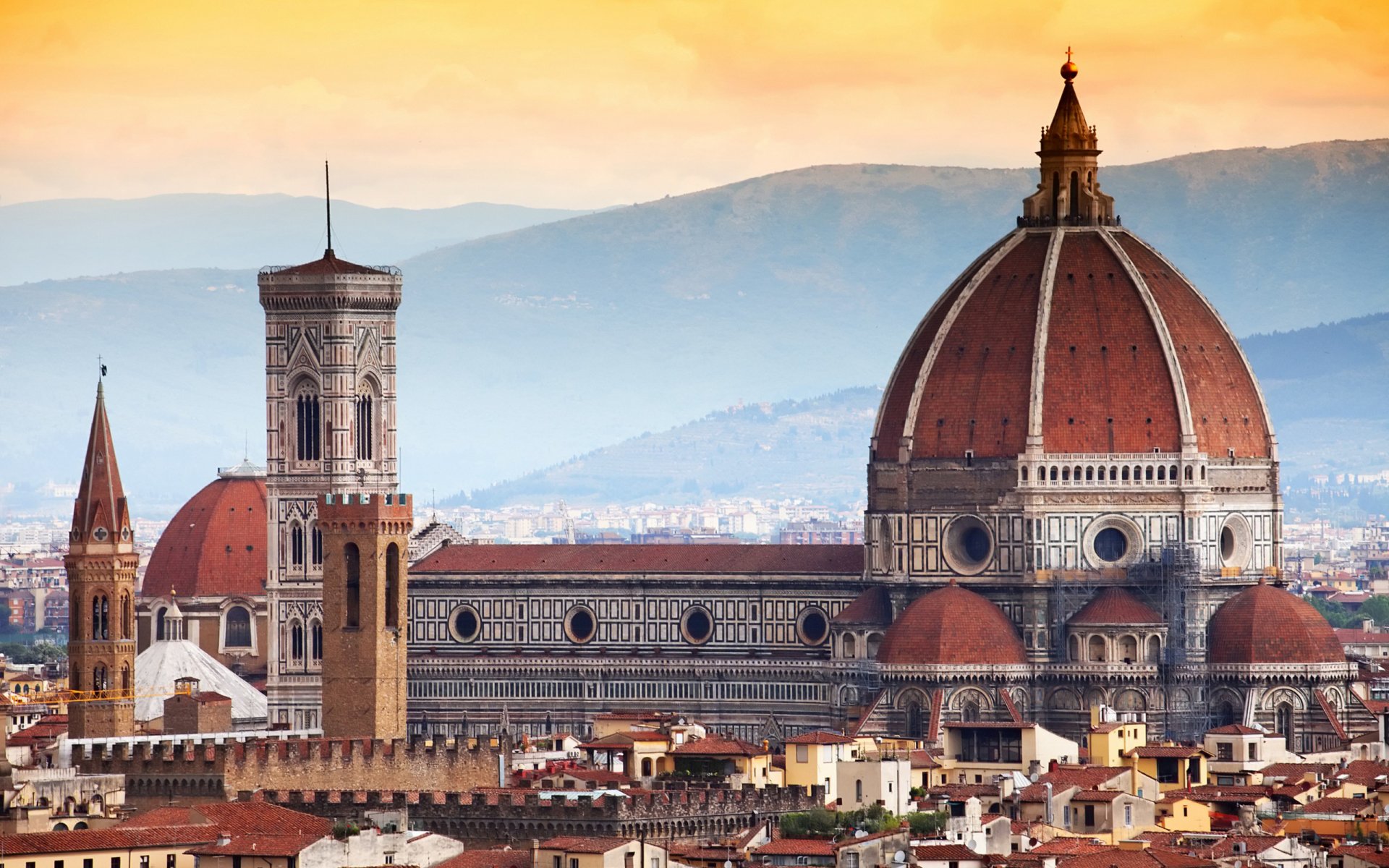 Religious view of the Basilica of Saint Mary of the Flower (Florence Cathedral) at sunset, dramatic dome and campanile above terracotta rooftops — 2K Quad HD PC desktop wallpaper/background.