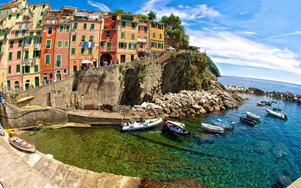 HD PC desktop wallpaper showing Riomaggiore's colorful man-made cliffside houses above a turquoise harbor dotted with small boats.