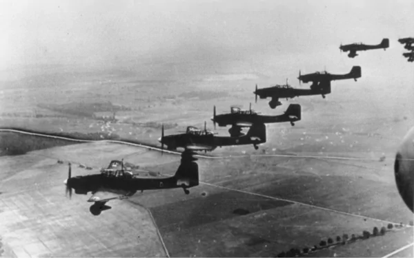Black-and-white HD military wallpaper showing a formation of Junkers Ju 87 dive bombers flying over a vast landscape.
