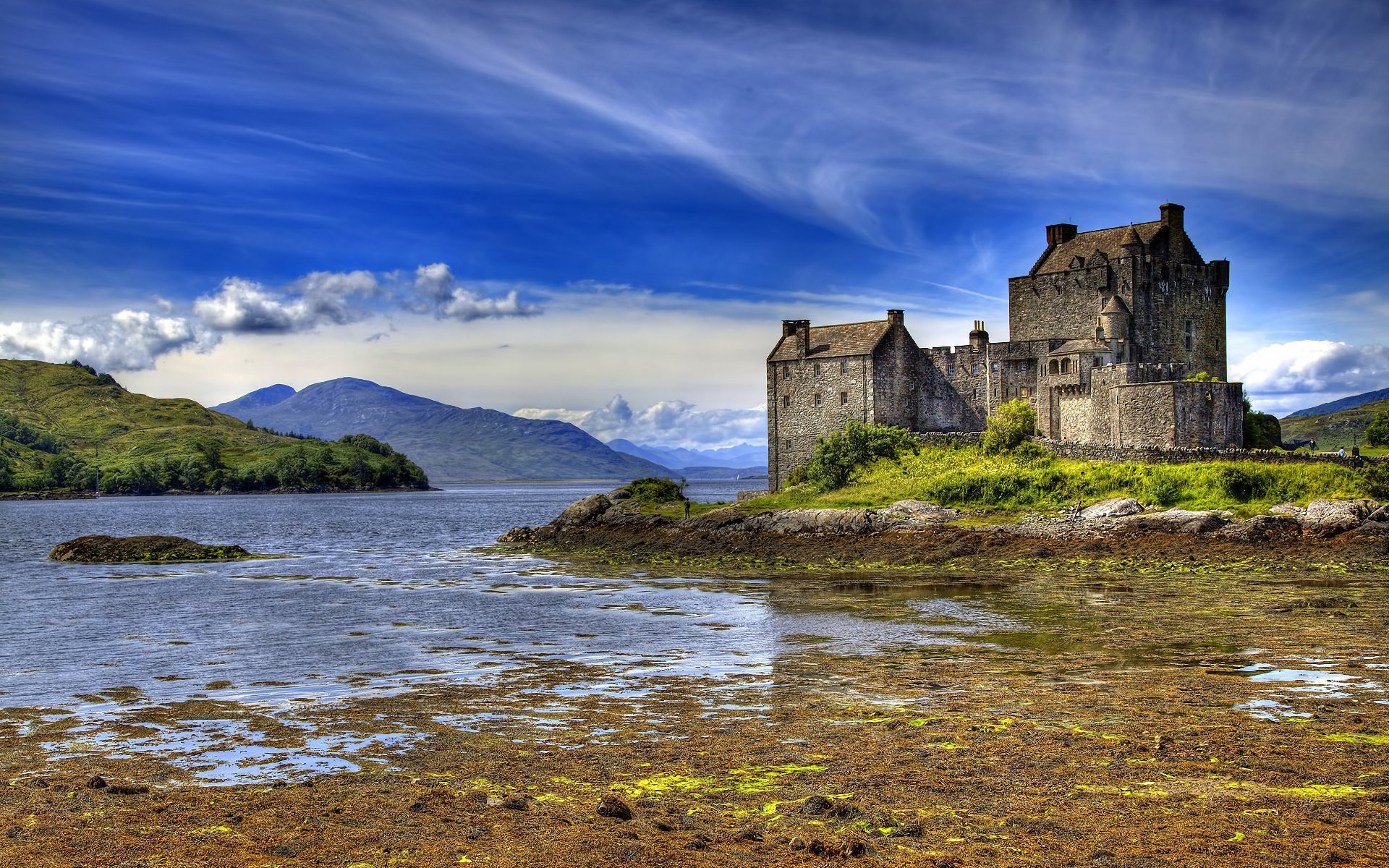 HD desktop wallpaper of Eilean Donan Castle, a historic man-made fortress set against a dramatic sky and tranquil waters.