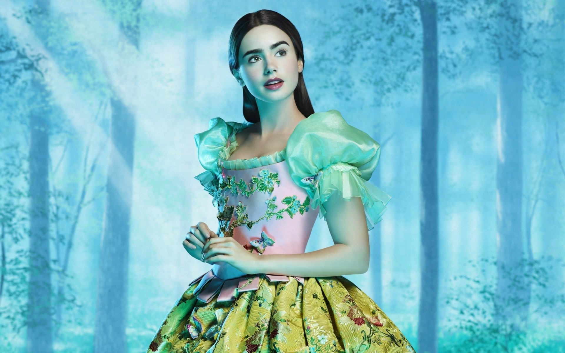 A stunning desktop wallpaper from the movie Mirror Mirror, featuring a character in an ornate gown set against a mystical forest backdrop, evoking a fairy tale atmosphere.
