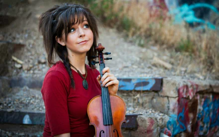 HD PC desktop wallpaper featuring Lindsey Stirling holding a violin outdoors, blending music and natural scenery for a striking visual background.