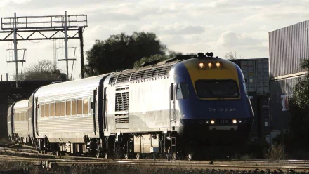 HD PC desktop wallpaper/background: New South Wales XPT train vehicle racing along sunlit tracks under a cloudy sky with rail gantries.