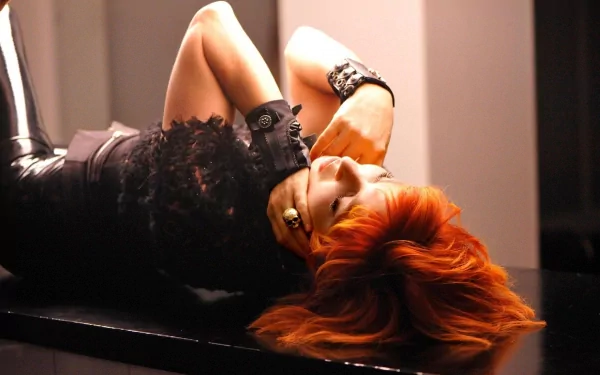 HD PC desktop wallpaper featuring Mylene Farmer, with striking red hair and a black outfit, capturing a dramatic and artistic music-inspired pose.
