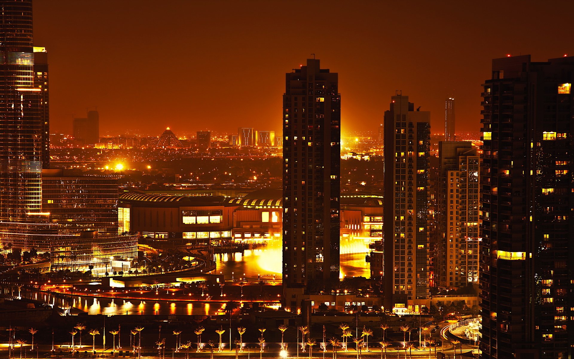 Nighttime view of Dubai’s illuminated skyline with modern skyscrapers and city lights, captured as an HD man-made cityscape for a PC desktop wallpaper background.