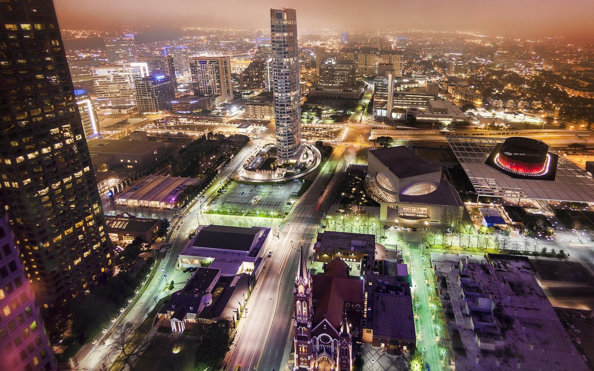 Aerial night view of man-made downtown Dallas skyline with illuminated skyscrapers, highways and arenas, rendered as an HD PC desktop wallpaper and background.