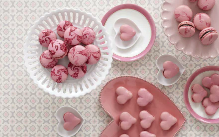 A delightful arrangement of pink cookies and heart-shaped treats displayed on elegant tableware, set against a patterned background, creating a charming food-themed desktop wallpaper.