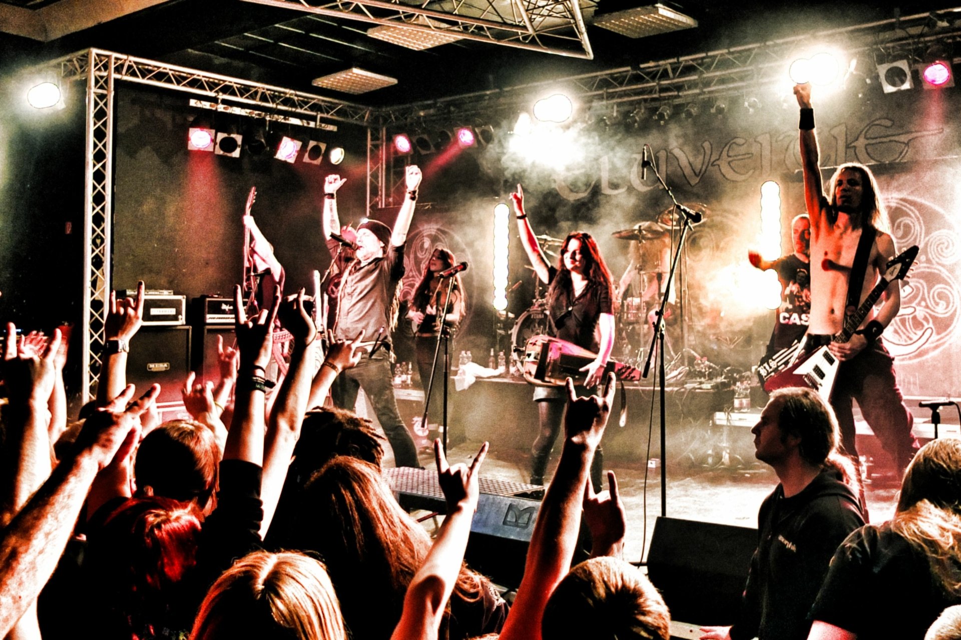 HD PC desktop wallpaper featuring Eluveitie performing live on stage with energetic lighting and an engaged crowd, capturing the intensity of their music.
