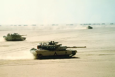 HD PC desktop wallpaper showing military tanks advancing across a sandy desert during the Gulf War.