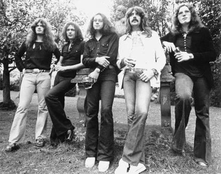 Black and white HD desktop wallpaper featuring the rock band Deep Purple posing outdoors among trees, capturing a classic music moment.