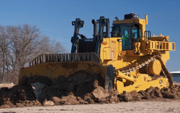HD desktop wallpaper featuring a yellow Caterpillar D11 bulldozer pushing earth on a clear day with a blue sky and bare trees in the background.