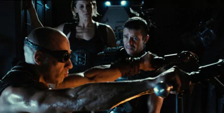 HD desktop wallpaper featuring a scene from Riddick with three characters in a tense moment aboard a spacecraft.