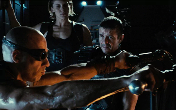 HD desktop wallpaper featuring a scene from Riddick with three characters in a tense moment aboard a spacecraft.