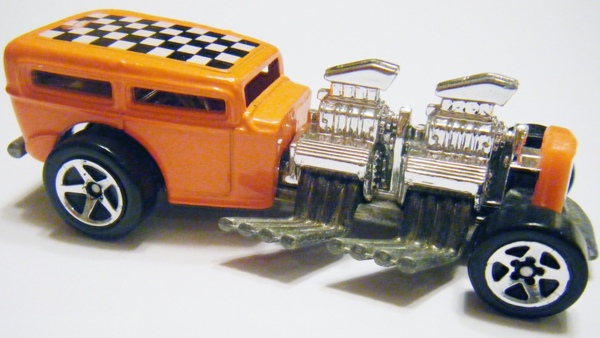 Close-up of a man-made orange Hot Wheels toy car with twin chrome engines and checkerboard roof on white 2K Quad HD PC desktop wallpaper/background.