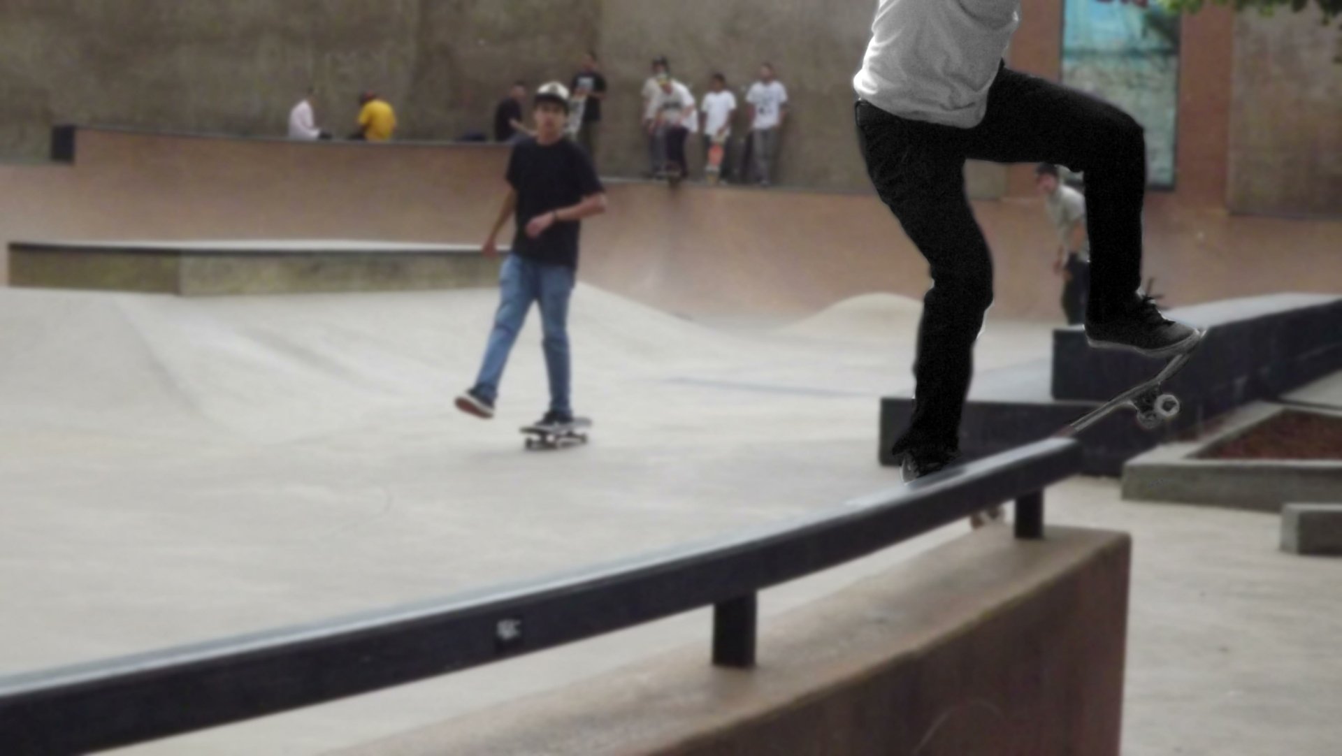 A dynamic 4K Ultra HD desktop wallpaper showing a skateboarder performing a grind trick on a rail in an indoor skatepark with other skaters in the background.