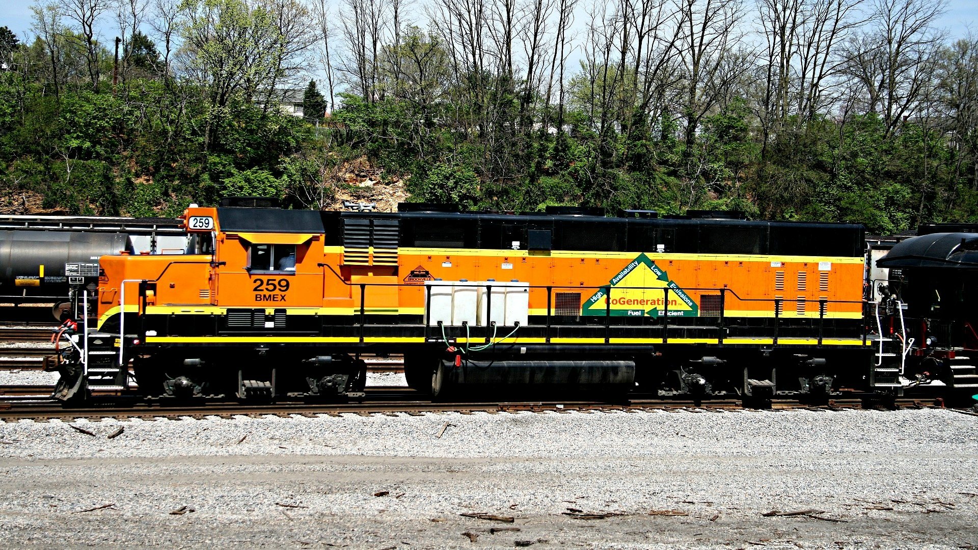 HD PC desktop wallpaper/background showing an orange freight locomotive (vehicle, train) numbered 259 parked on tracks with leafless trees and gravel foreground.